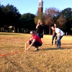 students using stakes and twine to create a cathedral shape on the Quad
