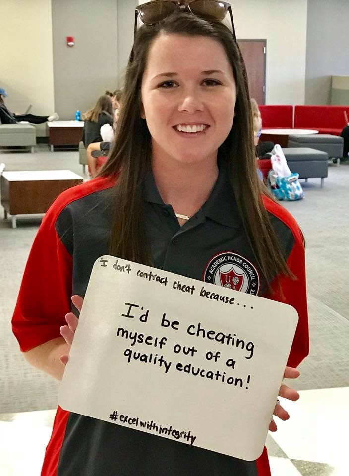 student holding whiteboard that says "I'd be cheating myself out of a quality education."