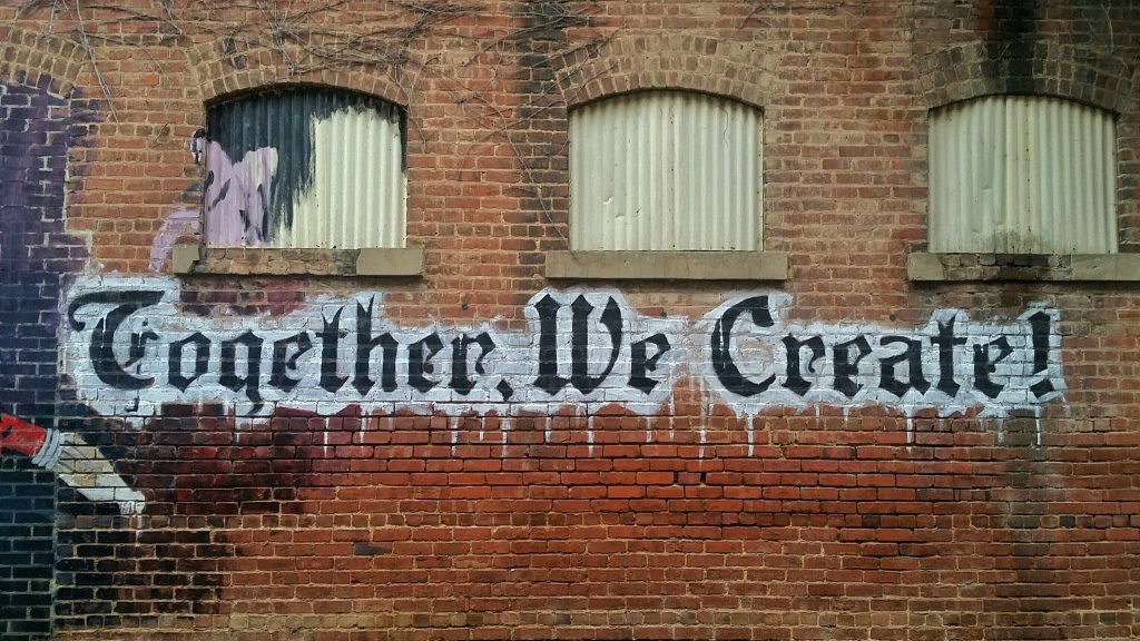 graffiti on wall saying "together we create"