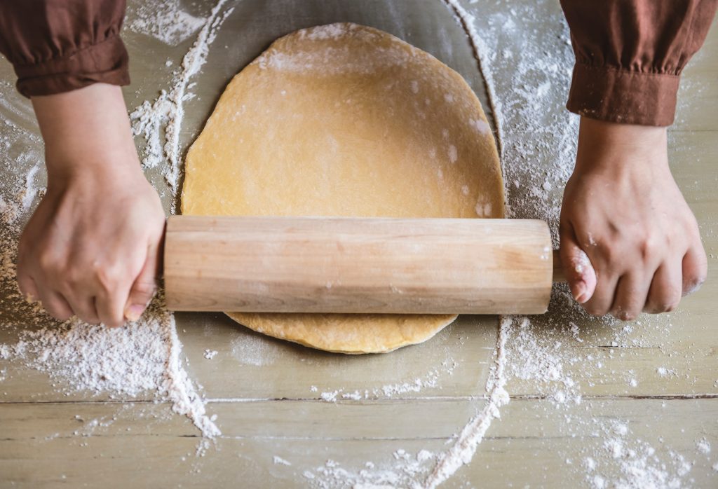 Dough being rolled out with a rolling pin