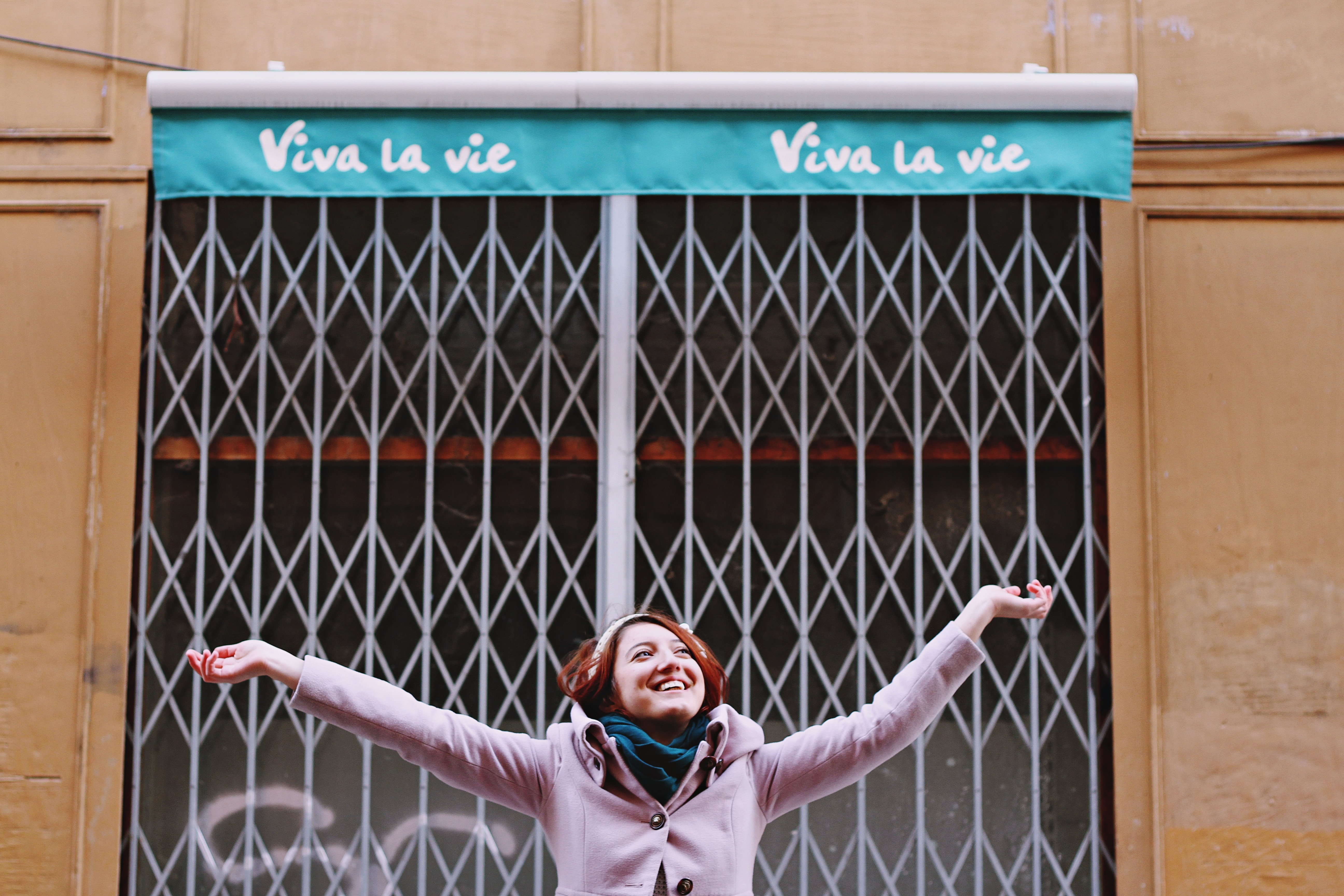 Happy young woman under a banner saying "Vive la vie"