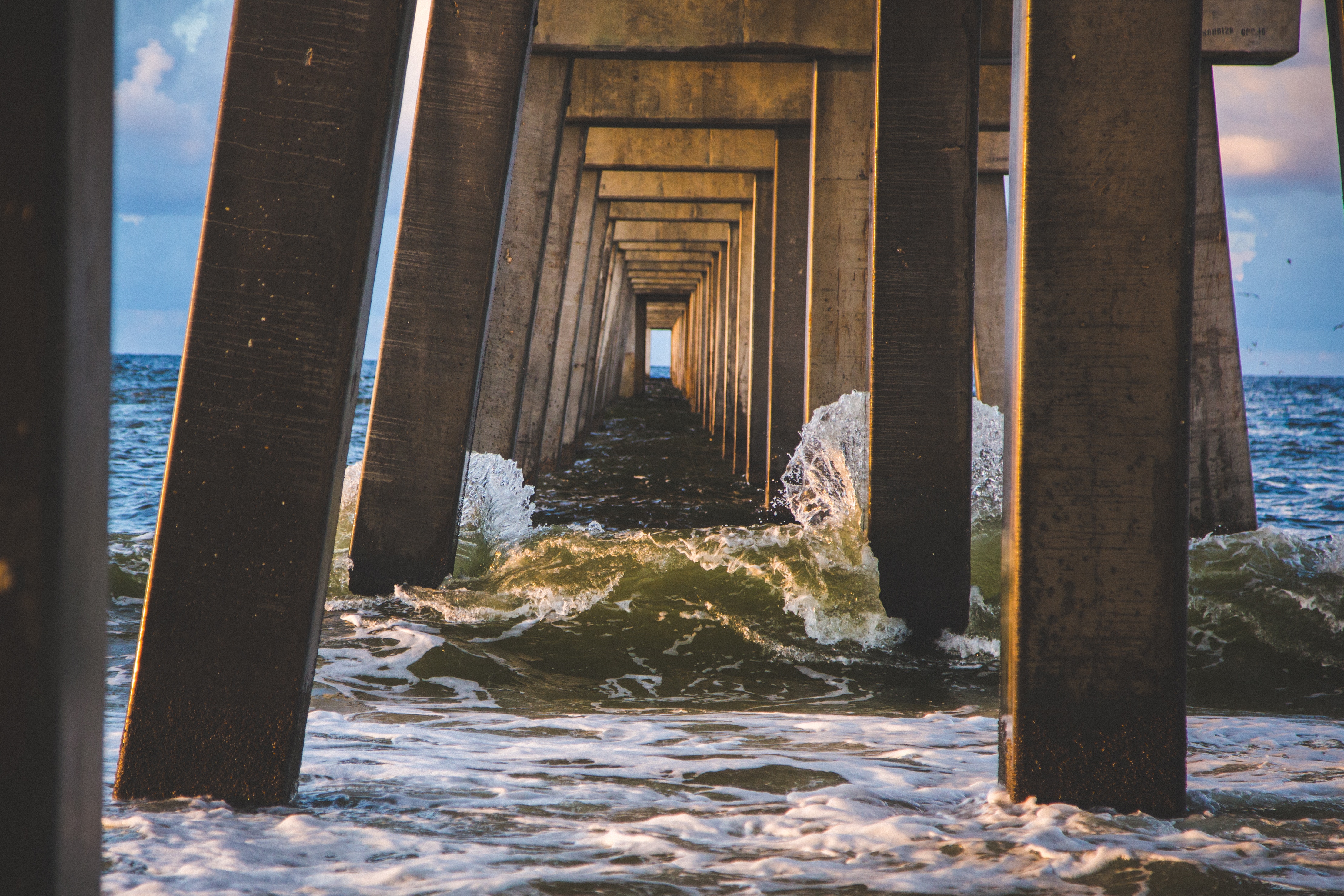 waves hitting the pillars of a pier.