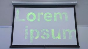 filler text in giant font with black background projected in a UA classroom