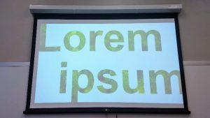 filler text in giant font with white background projected in a UA classroom