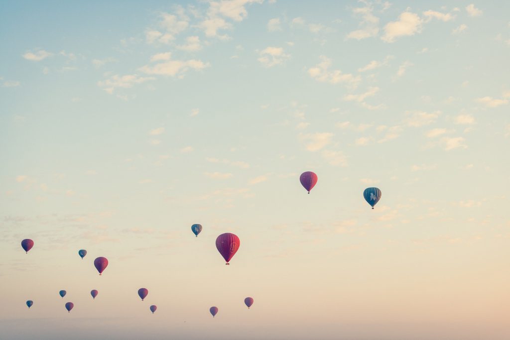 blue sky dotted with hot air balloons