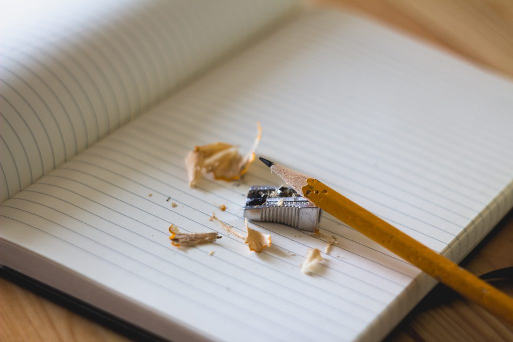 empty notebook with pencil and pencil sharpener